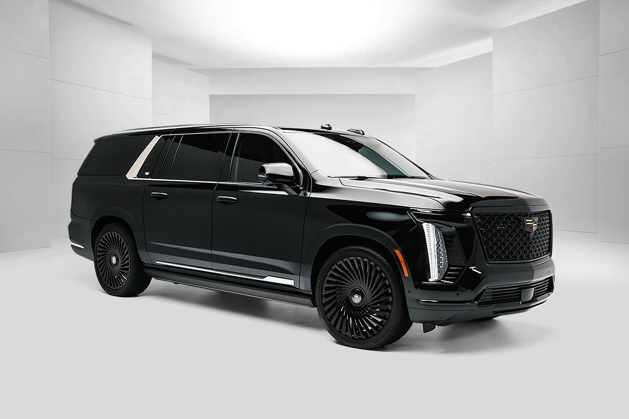 Black Cadillac SUV in a white studio setting